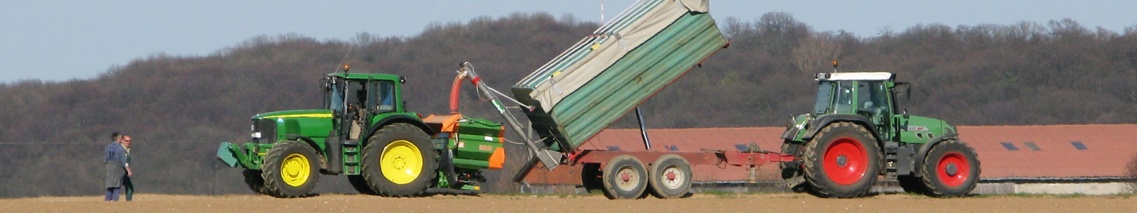 Traktor mit Düngestreuer und ein Traktor mit Anhänger auf einem  Feld ©Dr.Fritsch